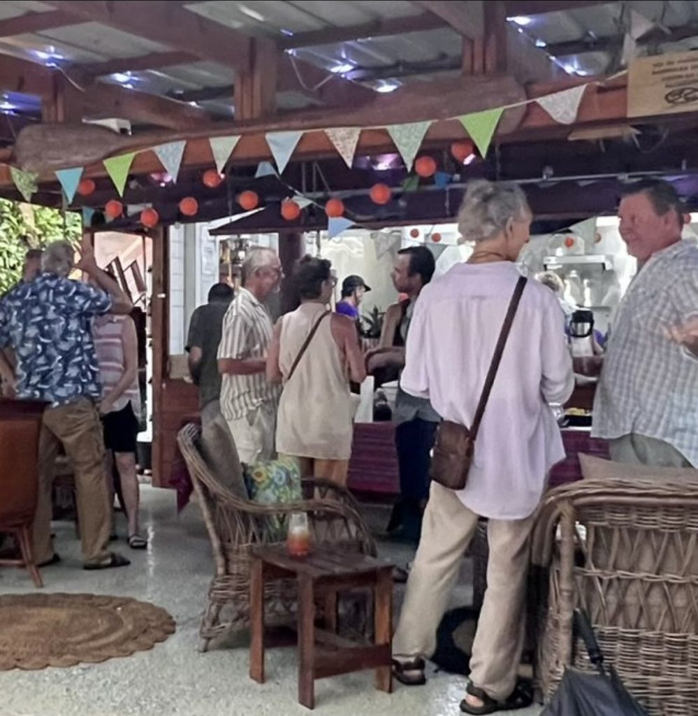Guests gathered and talking in the covered Seagrass Café, under strings of bunting.